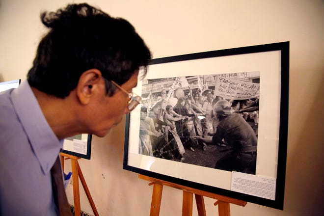 A guest looks at photographs taken by Horst Faas during the opening reception of The Associated Press photo exhibit, Thursday, June 11, 2015, in Hanoi, Vietnam. The exhibit "Vietnam: The Real War," a collection of 58 photographs taken by AP photographers during the Vietnam War that ended 40-years ago, opens to the public Friday, June 12, 2015, in Hanoi. (AP Photo/Wong Maye-E)