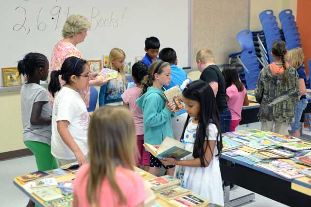 Students select books to take home at Pink Hill Elementary School on Tuesday after a 'Give 5, Get 5' book drive. About 2,691 books were donated by local churches, students, parents and businesses to ensure each student received five books of their choice.