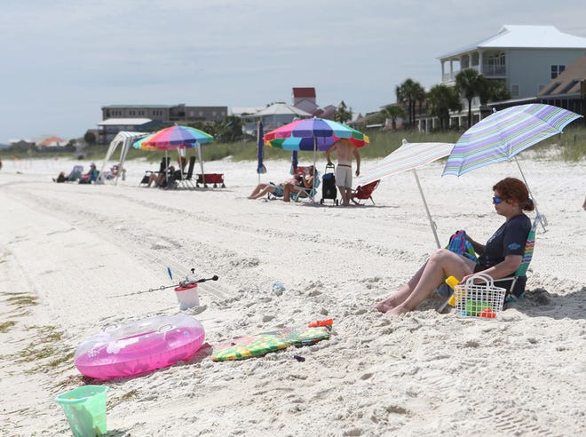 Visitors sunbathe on the shrinking shoreline in Mexico Beach June 10.