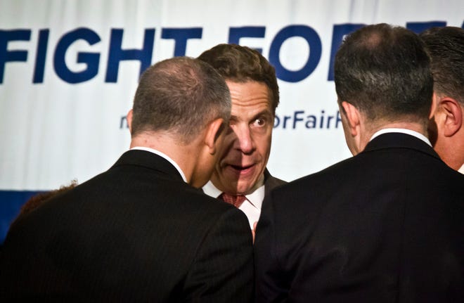 New York Gov. Andrew Cuomo, second from left, speaks with officials at rally for Fight for Fair Pay wage campaign, Thursday, June 11, 2015, in New York. As search continues for two escaped convicts, Gov. Cuomo said tracking dogs had picked up their scent. (AP Photo/Bebeto Matthews)