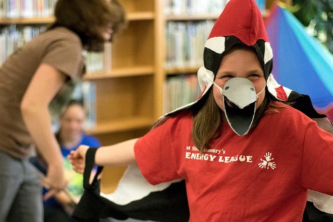 Morgan Hunt, 9, of Monmouth is dressed as a woodpecker as she assists in a demonstration during the Forest Nature Park Center event Thursday at the Warren County Library.