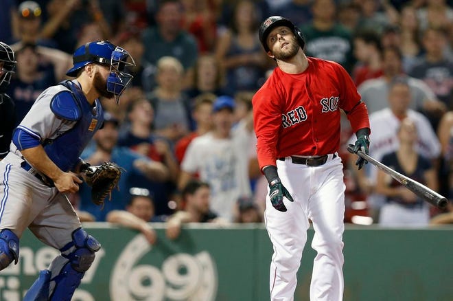 Boston Red Sox's Dustin Pedroia, right, reacts in front of Toronto Blue Jays catcher Russell Martin after striking out to end the baseball game in Boston, Friday, June 12, 2015. The Blue Jays won 13-10.