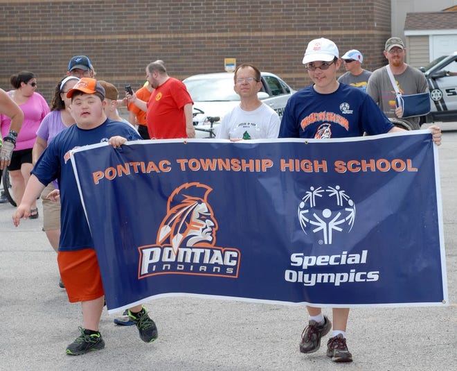 Special Olympic athletes Ronnie Fearman, left, and Adam Lopez carried the banner for Pontiac Township High School and Special Olympics Illinois during a parade in downtown Pontiac Thursday.