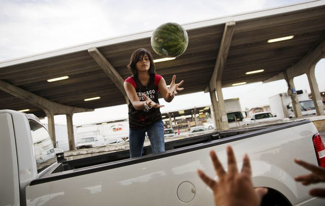 AP Photo/David Goldman In this June 6, 2015, photo, Ailyn Lopez, 13, catches a watermelon from her mother Maria Cantellano as they load up a customer's pickup truck at their stand at the Atlanta Farmers Market in Atlanta. The Labor Department reports on U.S. producer price inflation in May on Friday, June 12, 2015.