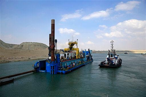 Dredgers work on a new section of the Suez canal during a media tour in Ismailia, Egypt, Saturday, June 13, 2015. Work on a parallel waterway to allow two-way traffic on Egypt's Suez Canal will be finished in time to allow ships to transit for a gala inauguration at the key trade route on Aug. 6, officials said Saturday. President Abdel-Fattah el-Sissi ordered the new waterway to be dug in a single year, saying that the urgency of Egypt's economic situation meant the project could not wait for an originally planned three-year timetable. (AP Photo/Hassan Ammar)