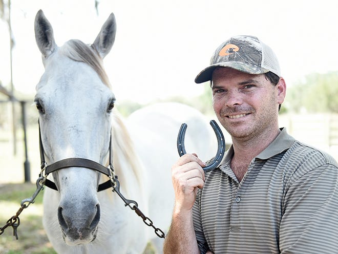 Aaron Rome, a farrier — that is, a horseshoer — from Myakka City, with Lezi, his quarter horse.