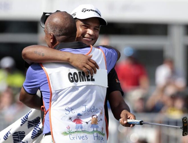 Fabian Gomez, of Argentina, celebrates with his caddie after sinking a birdie putt on the 18th green to win the St. Jude Classic golf tournament Sunday, June 14, 2015, in Memphis, Tenn.