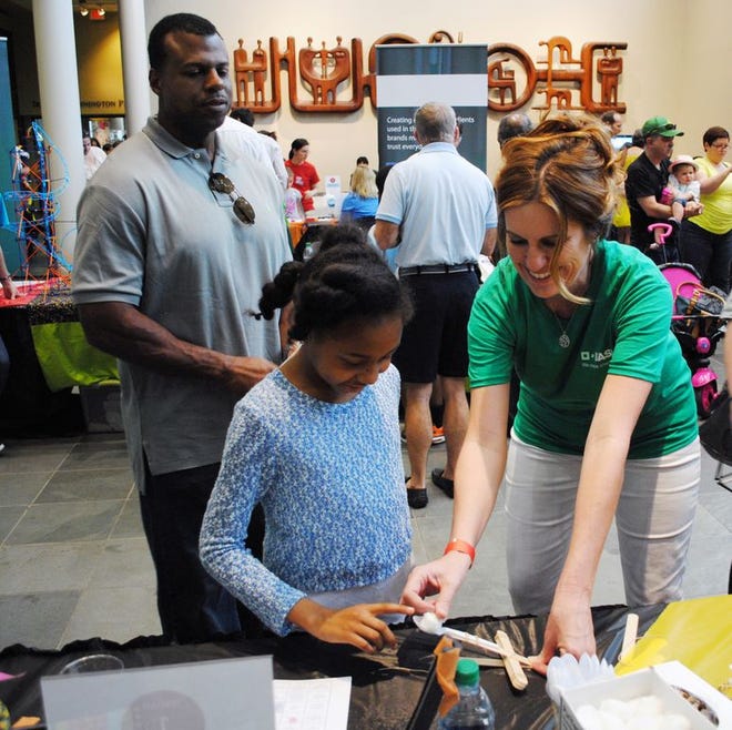 BASF employee volunteer Dana Scott assists a museum patron in creating a cotton ball catapult at the 2015 Louisiana Art & Science Museum Engineering Day.