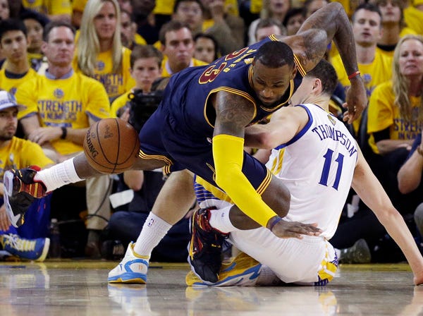 Cleveland forward LeBron James attempts to grab the ball against Golden State guard Klay Thompson during Game 5 of the NBA Finals on Monday. (Ben Margot | Associated Press)