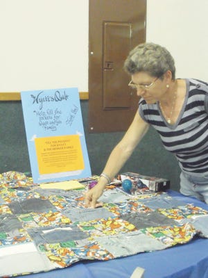 Wyatt’s Avenagers quilt was a popular stop during the benefit. Diane Furney donates money and stuffs it into a pocket. Julia Baratta photo