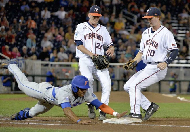 Ted Kirk Associated Press Florida's Buddy Reed (left) dives but is retired at first base during Monday night's loss to Virginia in the College World Series in Omaha, Neb.