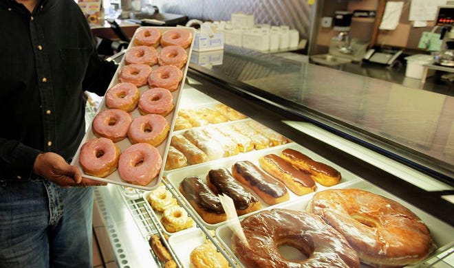 In this April 26, 2011 file photo, doughnuts are displayed in Chicago. The Obama administration is cracking down on artificial trans fats, calling them a threat to public health. The Food and Drug Administration said Tuesday that it will require food companies to phase out the use artificial trans fats almost entirely. Consumers aren't likely to notice much of a difference in their favorite foods, but the administration says the move will to reduce coronary heart disease and prevent thousands of fatal heart attacks every year. (AP Photo/M. Spencer Green, File)