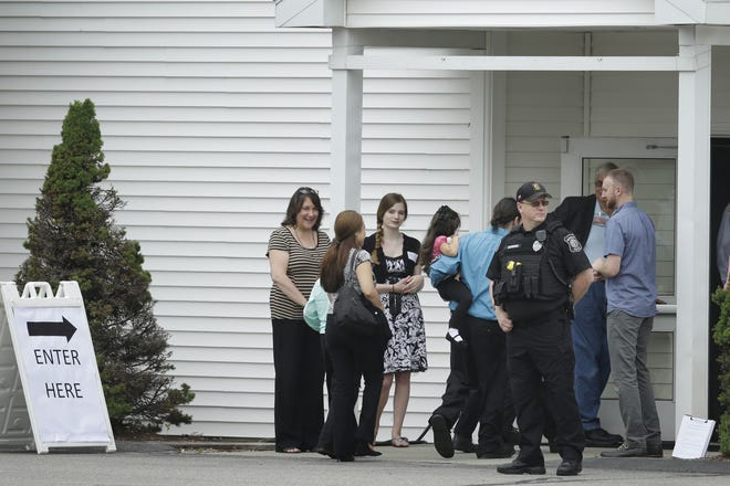 HUDSON - Mourners walk past a Hudson law enforcement official Tuesday as they enter Grace Baptist Church during a wake for Keith Broomfield, who was killed in Syria while fighting the Islamic State group. Broomfield, 36, who grew up in Bolton, is believed to be the first U.S. citizen to die fighting alongside Kurdish forces against Islamic State. The Associated Press