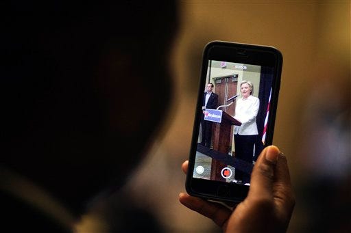 An audience member records Democratic presidential candidate Hillary Rodham Clinton on his phone as she speaks during a campaign stop, Wednesday, June 17, 2015, in Santee, S.C. (AP Photo/David Goldman)