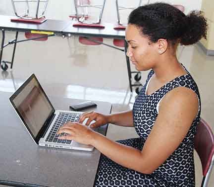 Patricia Edou, a recent Oak Ridge High School graduate, demonstrates a simple program and a few lines of code on her laptop.