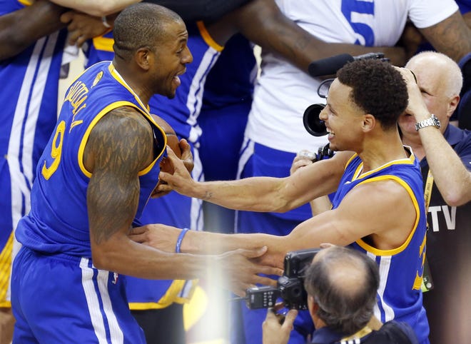 Golden State Warriors guard Stephen Curry, right, and guard Andre Iguodala celebrate after winning Game 6 of basketball's NBA Finals in Cleveland, Tuesday, June 16, 2015. The Warriors defeated the Cavaliers 105-97 to win the best-of-seven game series 4-2.