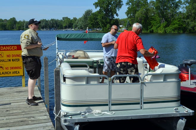Marine Patrol officer Austin Nichols conducts a safety inspection for boaters on Randall Lake. Don Reid photo