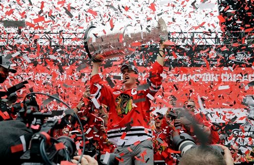 Chicago Blackhawks center Jonathan Toews holds up the Stanley Cup Trophy during a rally at Soldier Field for the NHL Stanley Cup hockey champions Thursday, June 18, 2015, in Chicago. (AP Photo/Nam Y. Huh)