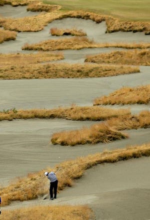 Phil Mickelson hits out of a fairway bunker on the 14th hole during the first round of the U.S. Open at Chambers Bay on Thursday in University Place, Wash. The course, riddled with mounds and sand, is so treacherous, two caddies were injured carrying their player's bags during practice rounds.