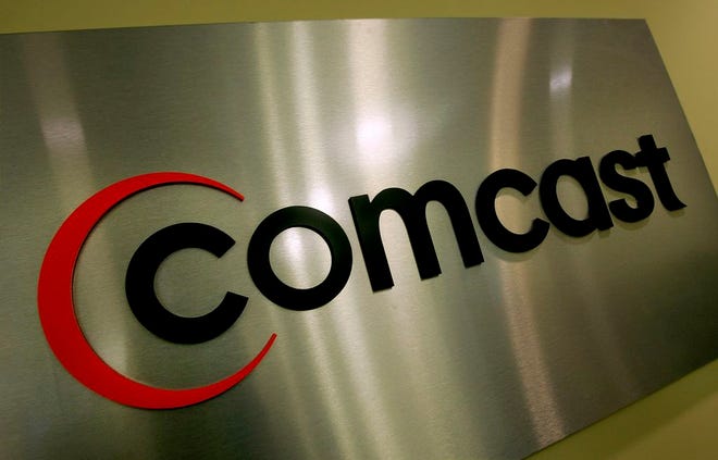 Comcast's name hangs in the lobby of its state headquarters in this Nov. 3, 2005, file photo, in Sandy, Utah.