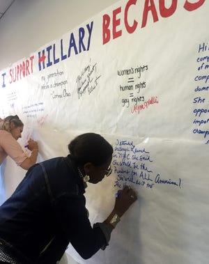 Jackie Weatherspoon, of Exeter, signs a poster signifying why she supports Hillary Clinton at the opening of her campaign's Portsmouth office. Photo by Jesse Scardina/Seacoastonline