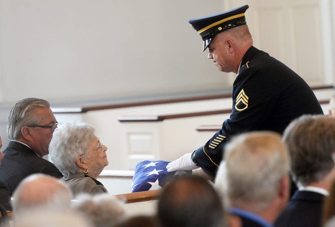 Phoebe Apgar Foster, wife of Bill Foster for 70 years, is given the American flag when honored by the military at Foster's funeral at First Parish Church in York on Thursday. Deb Cram/Seacoastonline