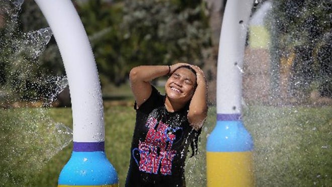 Rosalie Perez, age 17, of West Palm Beach cools off in the water park in Bill Moss Hillcrest Paseo in West Palm Beach Wednesday, June 17, 2015. Six members of her family came to beat the afternoon heat. A high pressure system is forecast to keep South Florida hot over the next few days, with temperatures reaching 89 degrees today and higher through the rest of the week. According to the National Weather Service, western areas of Palm Beach County could see 91 degrees on Friday and possibly as high as 93 Saturday.(Bruce R. Bennett / The Palm Beach Post)