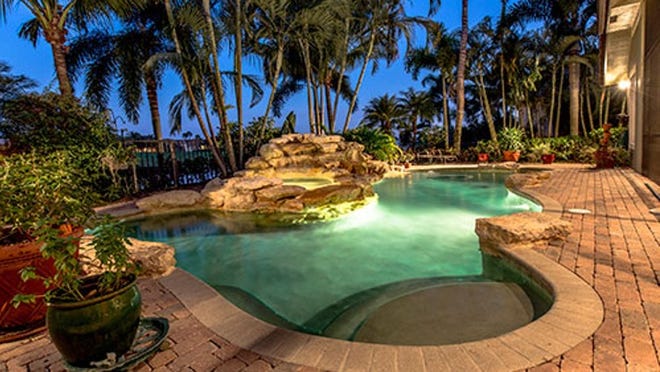This home features a rock waterfall pool and spa.