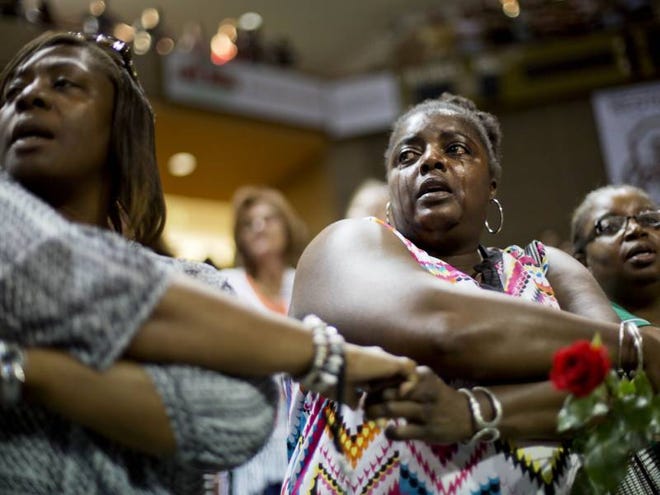 Barbara Lloyd, of Charleston, S.C., cries Friday as she joins hands with mourners during the singing of "We Shall Overcome" at a memorial service for the victims of the shooting at Emanuel AME Church in Charleston, S.C.