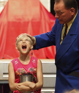 Macklyn Palmer, 9, of Burlington participates in a magic act, "Miser's Dream," as a part of Keith and Kitty's Magic Show during Kids Day Friday at Burlington Steamboat Days. Lauren Kastner/The Hawk Eye