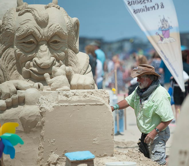 Justin Gordon of Massachusetts works on his entry, "BFF's :)", during the final day of the 15th annual Hampton Beach Master Sand Sculpting Competition on Saturday. John Carden photo