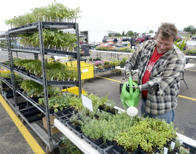 Daniel Dennis of Median waters his flowers that are for sale at the Hartville Flea Market.