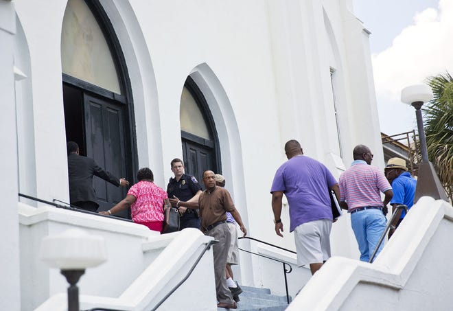 Church members walk into Emanuel AME Church as it opens after a cleaning crew finished working there Saturday, June 20, 2015, in Charleston, S.C. Congregation members say the historic black church where nine people were killed is going to re-open for Sunday morning service.