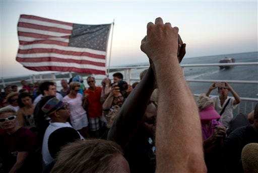 People raise their hands as a show of unity as thousands of marchers meet in the middle of Charleston's main bridge after nine black church parishioners were gunned down during a Bible study, Sunday, June 21, 2015, in Charleston, S.C. (AP Photo/Stephen B. Morton)