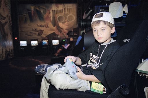 FILE- In this May 13, 1999, file photo, actor Jake Lloyd; who portrays young Anakin Skywalker in the film "Star Wars Episode I: The Phantom Menace;" plays a game during the Electronic Entertainment Expo in Los Angeles. Colleton County Sheriff's Sgt. Kyle Strickland said Sunday, June 21, 2015, that deputies on Wednesday arrested a 26-year-old man they confirmed through a former talent agent Lloyd. Lloyd faces charges after leading South Carolina deputies on a high-speed chase.