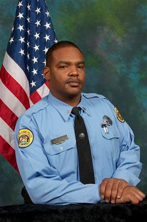 This undated photo provided by the City of New Orleans shows Officer Daryle Holloway. The New Orleans Police Department said Holloway was shot while transporting a suspect, Travis Boys, who managed to get his handcuffed hands from behind his back to the front, grab a firearm and shoot the officer. A manhunt was underway for the 33-year-old Boys, according to Police Chief Michael Harrison. (City of New Orleans via AP)