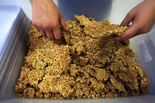 Freshly baked granola hot from the oven is broken into bitesize pieces. Wildtime Foods makes organic granola in its new location in the Whiteaker neighborhood. (Paul Carter/The Register-Guard)