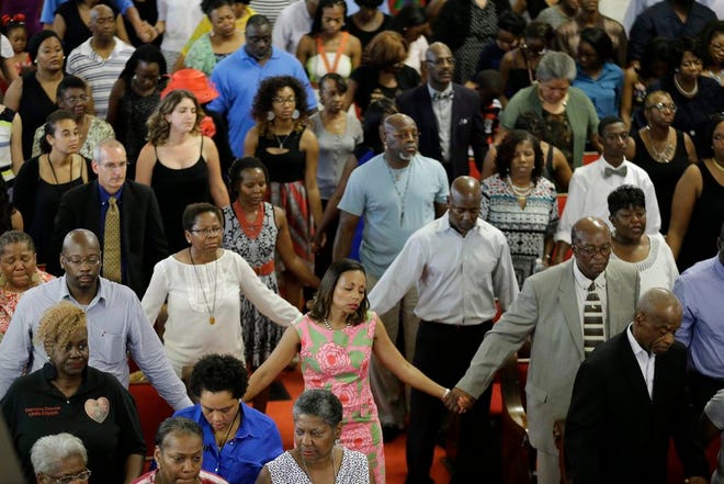 Parishioners sing at the Emanuel A.M.E. Church in Charleston, S.C., on Sunday, four days after a mass shooting that claimed the lives of its pastor and eight others. The Associated Press