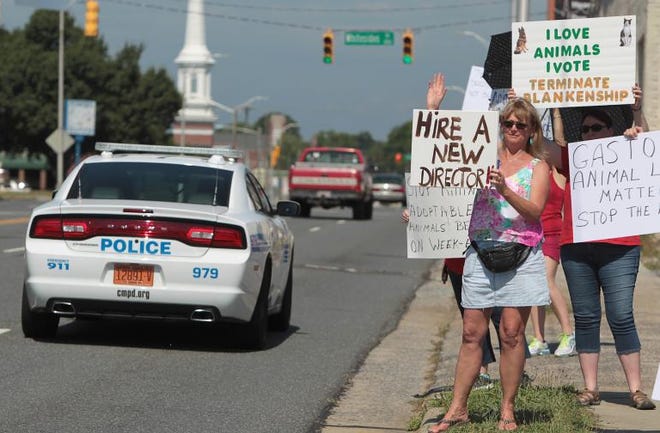 (Photo Mike Hensdill/The Gaston Gazette) A rescue group protested against Gaston County Animal Control for better treatment for animals Saturday, June 20, 2015 on West Franklin Blvd. in front of the Gaston County Police Department. Here, Diane Griffith (front) and others hold their signs to show passing motorists.