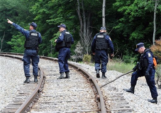 New York State Department of Corrections officers search the railroad tracks after a possible sighting of the two murder convicts who escaped from a northern New York prison two weeks ago, Sunday June 21, 2015, in Friendship, N.Y. State police said a woman on Saturday reported spotting two men who resembled the convicts near a railroad line that runs along a county road. (AP Photo/Gary Wiepert)