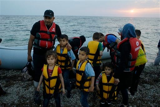 FILE - In this Thursday, June 18, 2015 file photo, Syrian migrants arrive by dinghy from the Turkish coast, at a Mytilene's beach, on the northeastern Greek island of Lesbos. More than 25,000 people have arrived on the island of about 80,000 inhabitants since the start of the year. (AP Photo/Thanassis Stavrakis, File)