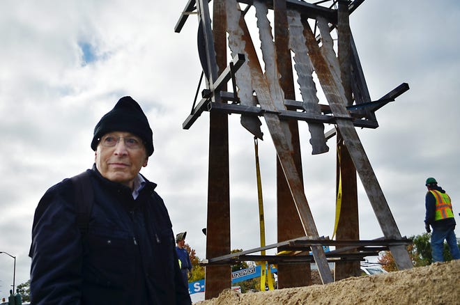 Cyril Lixenberg stands to the side of the River Avenue bridge and watches his artwork the 'Uniting Sun' placed onto the ground after arriving Tuesday, Oct. 21, 2014. Sentinel file
