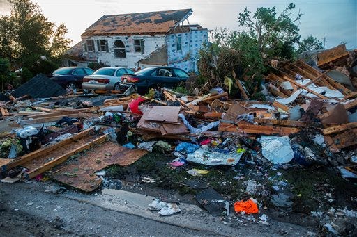 Debris surrounds vehicles Tuesday, June 23, 2015, after a severe storm passed through Coal City, Ill. on Monday night. Coal City Mayor Terry Halliday said a suspected tornado swept into town, first striking the high school before moving to the southeast over homes and damaging a fire station.