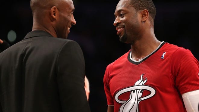 Dwyane Wade (right) of the Miami Heat and Kobe Bryant of the Los Angeles Lakers meet after the game at Staples Center on December 25, 2013 in Los Angeles, California. There are reports of mutal interest between Wade and the Lakers, but some wonder how Wade and Bryant — two aging shooting guards — would mesh as teammates. (Photo by Stephen Dunn/Getty Images)