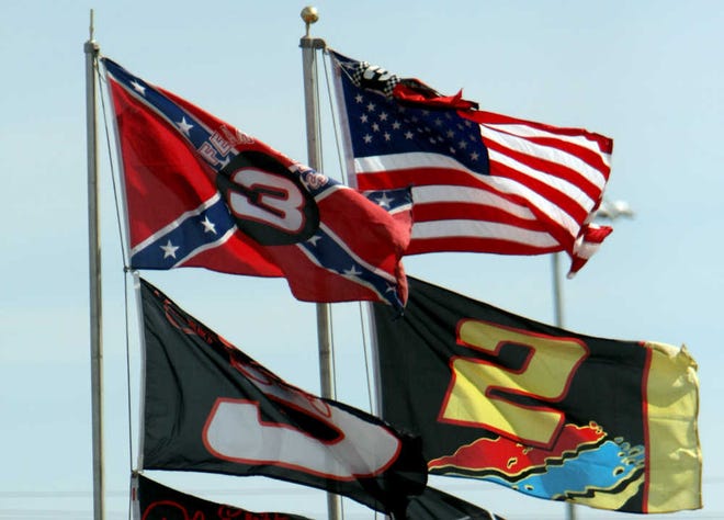 FILE - In this Feb. 15, 2008, file photo, flags, including a Confederate flag, fap in the wind during practice for the NASCAR Sprint Cup Series Daytona 500 auto race at Daytona International Speedway in Daytona Beach, Fla. NASCAR is backing South Carolina Gov. Nikki Haley's call to remove the Confederate flag from the South Carolina Statehouse grounds in the wake of a massacre at a Charleston church, it said in a statement Tuesday, June 23, 2015. Though NASCAR bars the use of the flag in any official capacity, many fans fly the flag at their races. (AP Photo/Darryl Graham, File)
