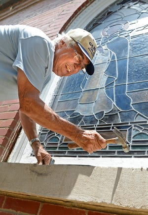 BRIAN D. SANDERFORD • TIMES RECORD Doug Gammon with Immaculate Conception Church in Fort Smith repairs the trim around a stained glass window at the church on Monday, June 22, 2015. Gammon said in time all of the windows in the building will be repaired. Once the trim is finished a clear covering is placed over the window to protect the stained glass from the elements.