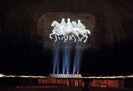 In this May 19, 2011 photo, a giant carving commemorating the military and political leaders of the Confederacy is lit up by lights on Stone Mountain, Ga. Calls to remove Confederate imagery from public places multiplied rapidly across the South and beyond Tuesday, June 23, 2015, in the wake of the mass shooting at a historic black church in Charleston, S.C. (Hyosub Shin/Atlanta Journal-Constitution via AP)