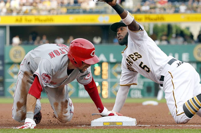 Reds outfielder Billy Hamilton, left, steals third as  Pirates third baseman Josh Harrison looks to the umpire for the call in the first inning of Wednesday's game at PNC Park. The Reds won 5-2.