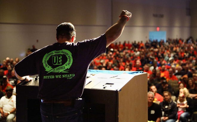 UE Local 506 President Scott Slawson speaks to members gathered June 13 at the Bayfront Convention Center in Erie. More than 5,000 United Electrical, Radio, and Machine Workers of America who work at GE Transportation in Lawrence Park Township attended the rally. BRYAN BENNETT/