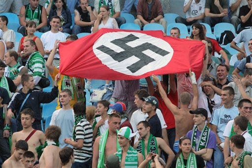 In this photo taken Aug. 19, 2007 soccer fans show a German Nazi flag with a swastika during an Ukrainian League Championship soccer match between Dynamo Kyiv and Karpaty in Kiev, Ukraine. With the defeat of Adolf Hitler in 1945, the Nazi's scarlet flag with a black swastika was banned in Germany and remains so today. The banner once hung from all official buildings in the Third Reich, was waved madly by the cheering crowds that supported Hitler and the Nazis, and was an integral part of military and other uniforms. Synonymous with the genocidal policies of the Nazis, the flag, the swastika and all other such symbols are illegal to display today, but remain favorites of neo-Nazis and other right-wing extremists, both inside Germany and around the world. After the war, the swastika was chiseled out of the talons of the stylized stone eagle that featured on many Nazi buildings, but today there is now a debate about whether the bird itself should go as well. (Ukrinform via AP)